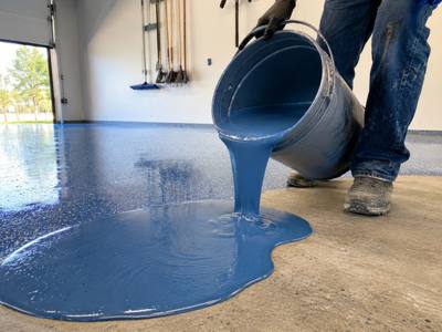 Blue base coat spreading out over a freshly ground slab