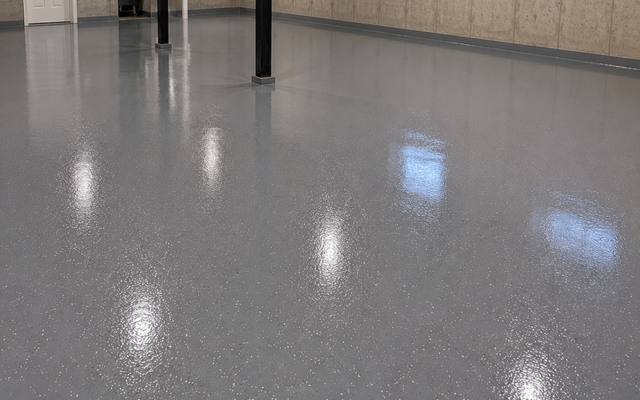 Bare concrete slab coated wall to wall in a flat grey system