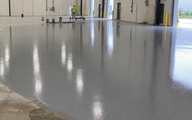 Industrial coating being pulled out across a warehouse slab